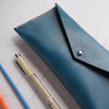 The Dyed Leather Pencil Case that has been hand dyed with blue leather colour and hand stitched with waxed white linen thread.