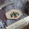 This camping patch has been engraved with numerous trees and tents.