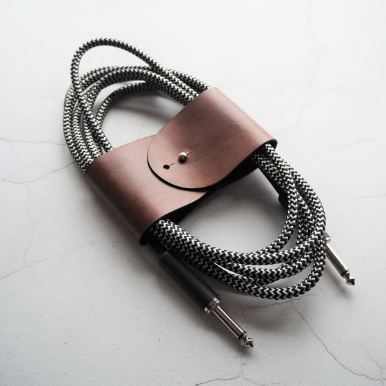 A guitar cable that's tanlge free and wrapped with the Guitar Cable Tidy, a leather cable tidy from HÔRD.