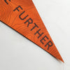 A close up of the Hike Further leather pennant - The perfect gift for those who love to get outside and push themselves to hike as far as possible an climb up mountains. Ideal for anyone who has tackled the three peaks challenge. A hiking home decor from Hord.
