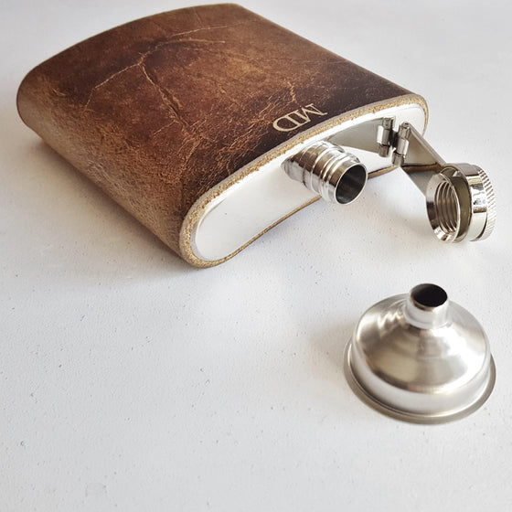 A personalised hip flask from Hôrd, featuring the initialled oak flask that's made with luxurious british leather.