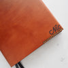 Custom initials engraved onto the monogrammed leather notebook cover.