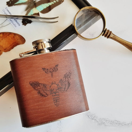 This nice hip flask is engraved with 2 moths.