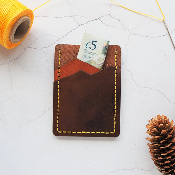 The Vertical Mountain Card Holder, a vertical card holder with cash stored in one of the compartments.