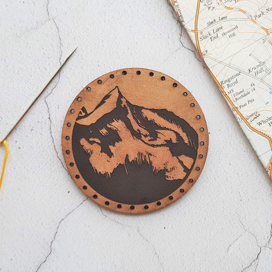 The mountaineer Patch by HORD - This leather patch is hand dyed and engraved with wonderful mountains. Perfect stocking fillers or gifts for lovers of the outdoors, mountaineering and hiking.