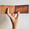 A person holding the engraved leather wallet, the Mountain Wallet, Slimline Bi-Fold by Hord. 