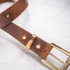 Closer look at the solid brass hardware of the tan leather belt.