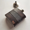 This Peat and Black Leather Flask is engraved with a custom initial on the bottom right corner.