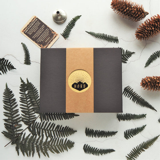 The Peat and Black Leather Flask is packaged in a gift box with a funnel and care instructions.