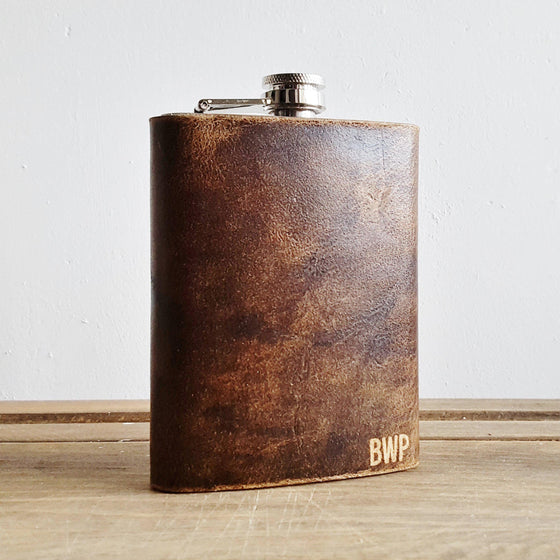 The Personalised Leather Hip Flask from HÔRD that's engraved with a custom initial on the bottom right corner.