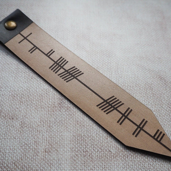 This personalised leather bookmark has been engraved with a custom text with the ancient Ogham language.
