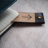 The personalised leather bookmark being used on a journal.