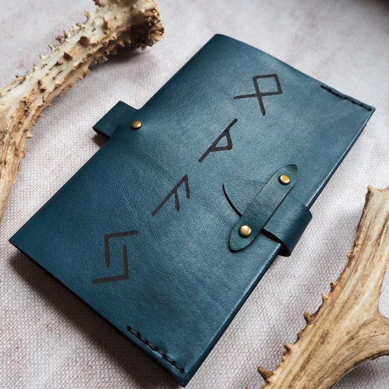 An A6 Notebook Cover featuring ancient runes engraved onto the journal cover. 
