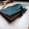 The Viking Rune Leather Pocket Journal Cover on an A6 journal with the clasp opened.