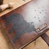 The Bear & Butterfly engraved leather notebook with the clasp unclasped.