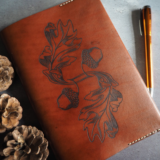 Full view of the Acorn notebook cover featuring oaknut and leaves engraving, a planner cover from HÔRD.