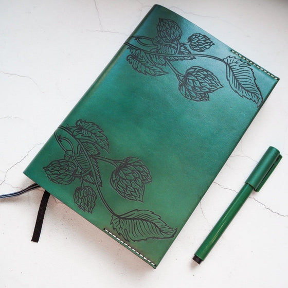 The Beer Journal decorated with hop flowers and vines. This luxury notebook is hand dyed in green with natural stitching.