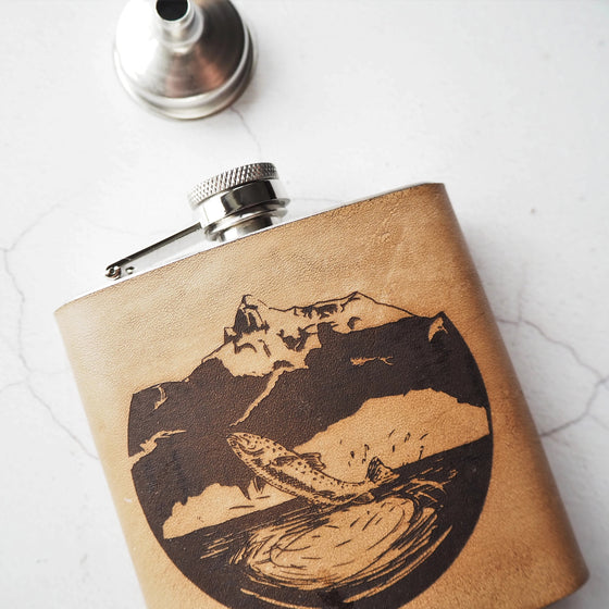This fishing hip flask is engraved with a trout leaping from the waters of the mountain glade.