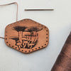This antiqued light brown leather patch is engraved with a cluster of mushrooms and a variety of funghi, a great gift for someone who loves foraging and eating ceps. The forager patch from Hord.