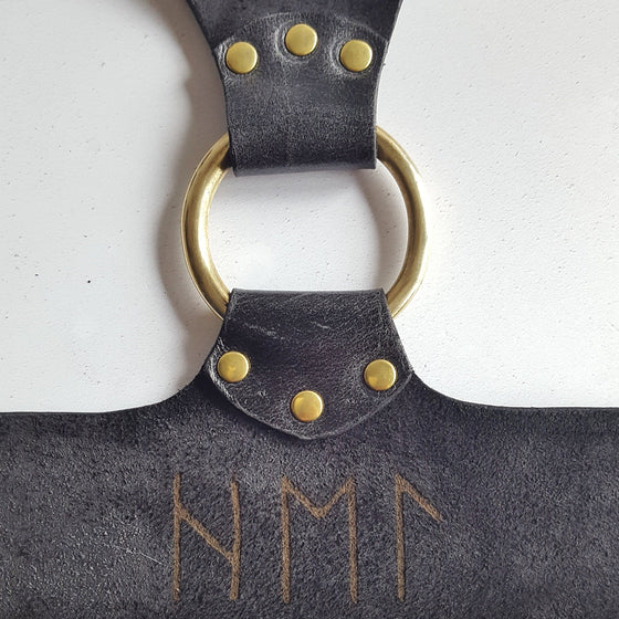 This leather chest harness has been personalised in runes.