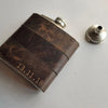 This engraved leather hip flask comes with a funnel.