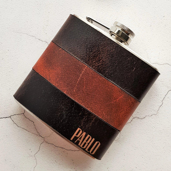 The Peat and Rust Leather Flask is engraved with a name or initial on the bottom right corner of the flask.