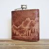 This outdoor hip flask is engraved with an illustration of the mountains and trees.