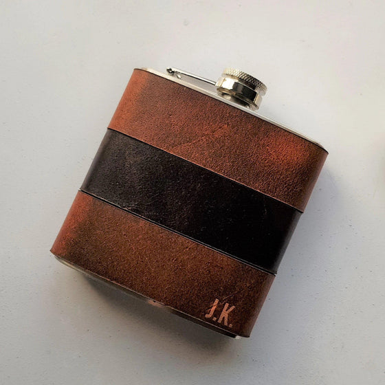 The Rust and Peat Leather Flask that has been engraved with a custom initial.
