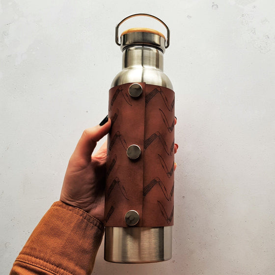 The Scout Adventure Bottle by HORD in Medium Brown - Hot drinks are kept hot for 12 hours and cold drinks are kept chilled for 24 hours - the bottle opening is also wide enough to fit standard ice cubes. The wrap is attached with 3 steel poppers. The bottle holds 600 ml and is BPA free.