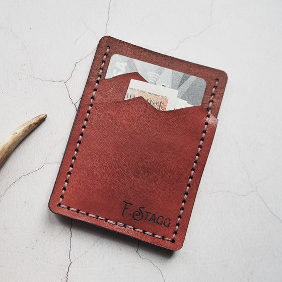 The Stag Card Holder with a card and money stored on its compartments.