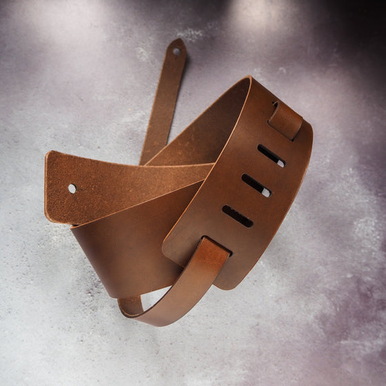Full view of the thick leather guitar strap by HÔRD in brown.
