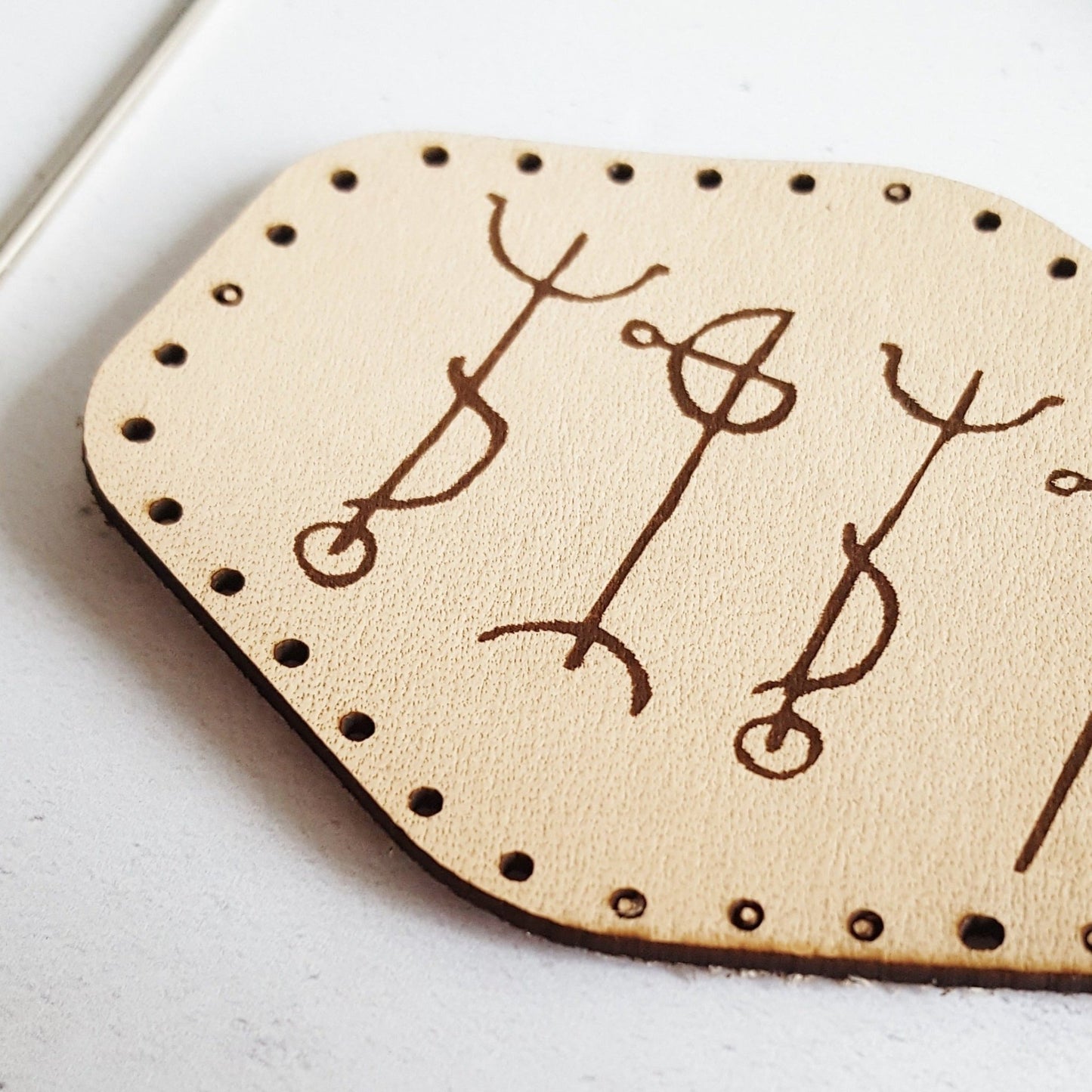 A close up of HORD's draumstafir viking stave patch, a runic patch showing the grain and texture of the leather