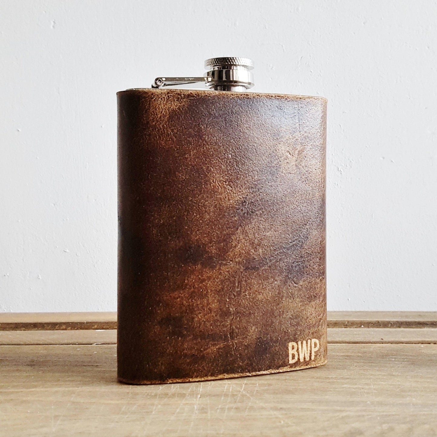 The Personalised Leather Hip Flask from HÔRD that's engraved with a custom initial on the bottom right corner.