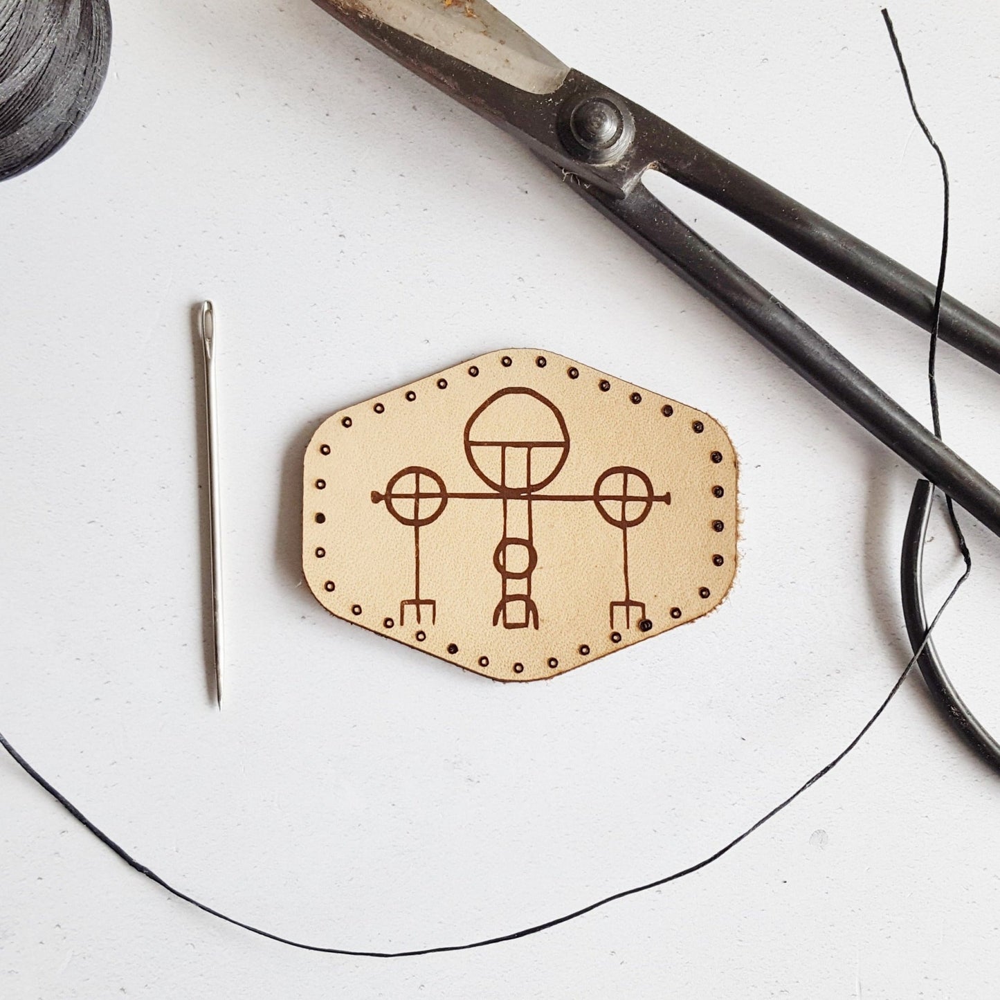 This natural leather patch is engraved with rohringur minni, an ancient Icelandic magical stave which grants protection for the wearer