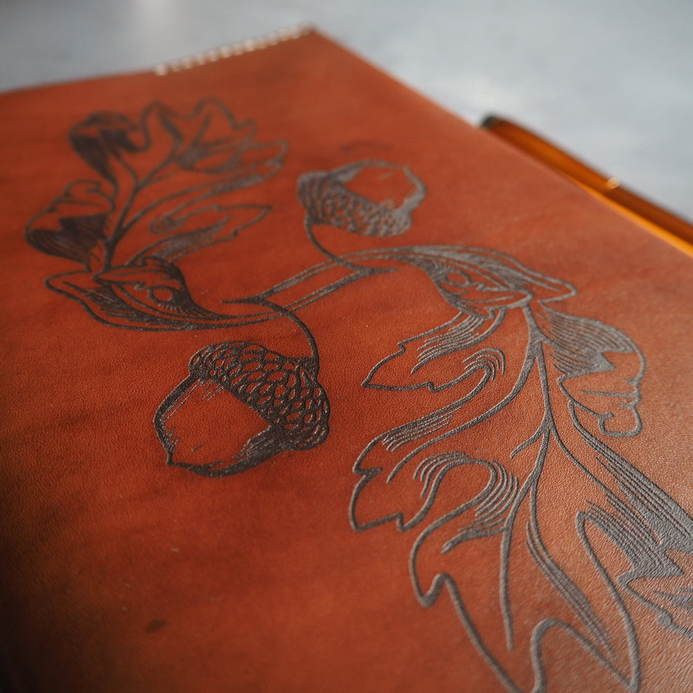 
                  
                    The Acorn Notebook Cover on medium brown leather colour. 
                  
                
