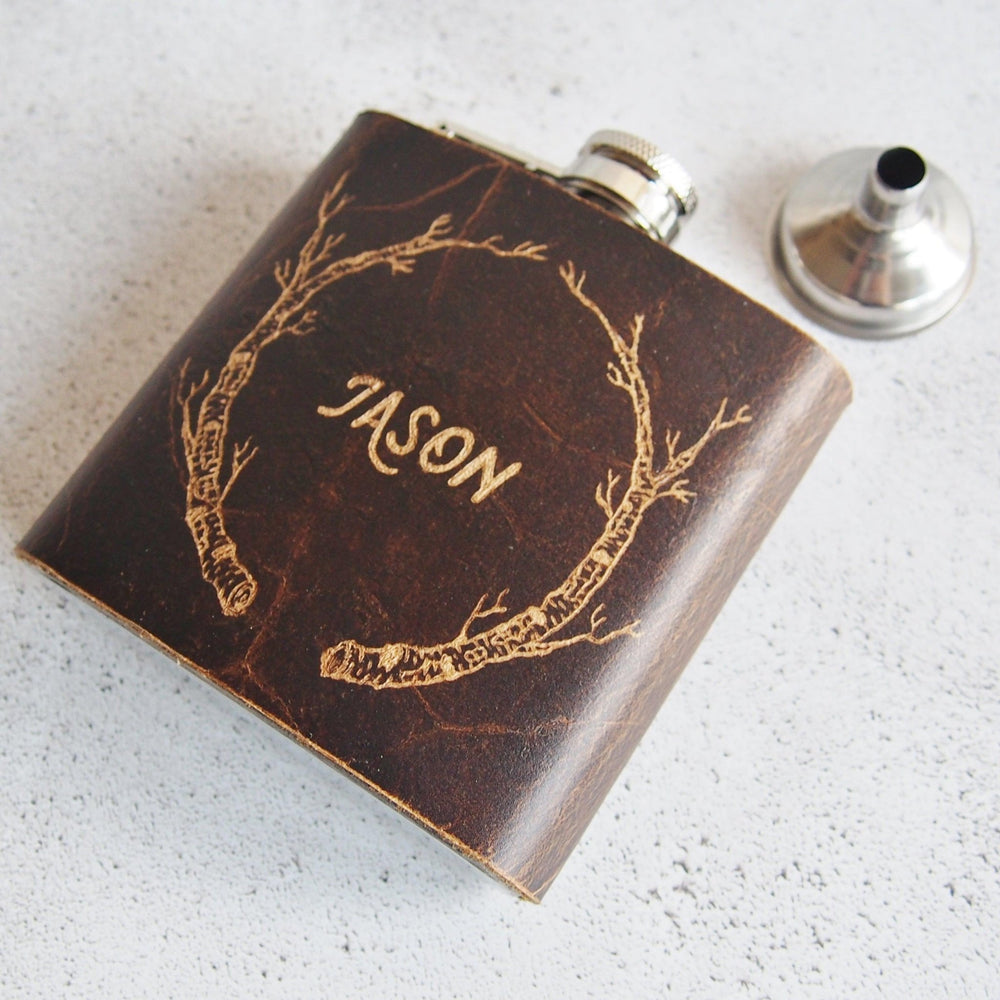 
                  
                    This groomsman hip flask is engraved with a custom name and a birch branch.
                  
                