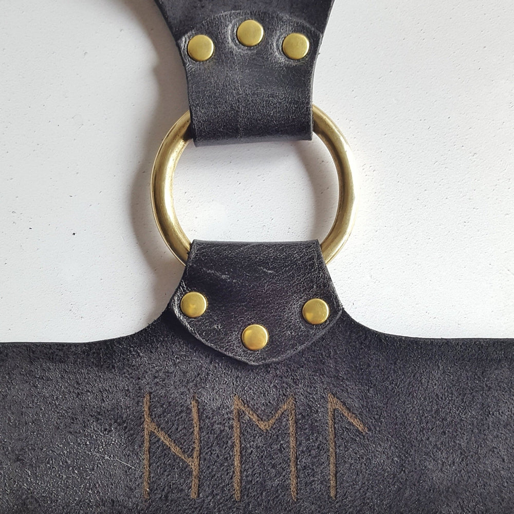 
                  
                    This leather chest harness has been personalised in runes.
                  
                