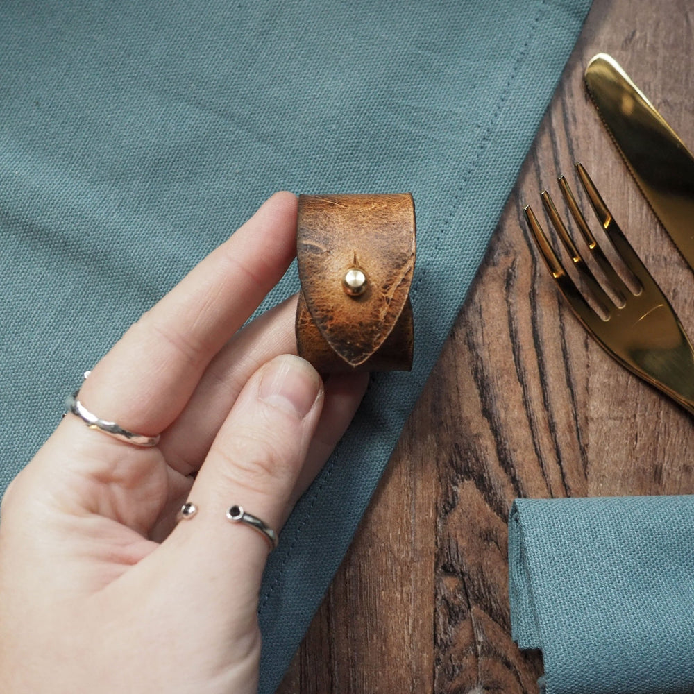 
                  
                    A person holding onto the Rust Napkin Ring by HÔRD. 
                  
                