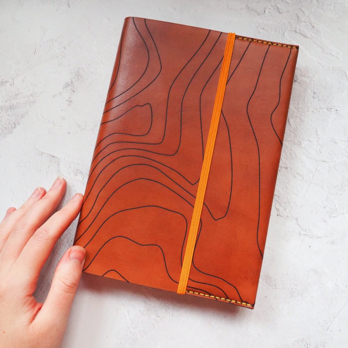 The topography journal cover in light brown leather colour.